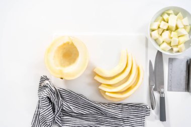 Düz yatıyordu. Beyaz kesme tahtasında kaygan altın çiğ taneli kavun.