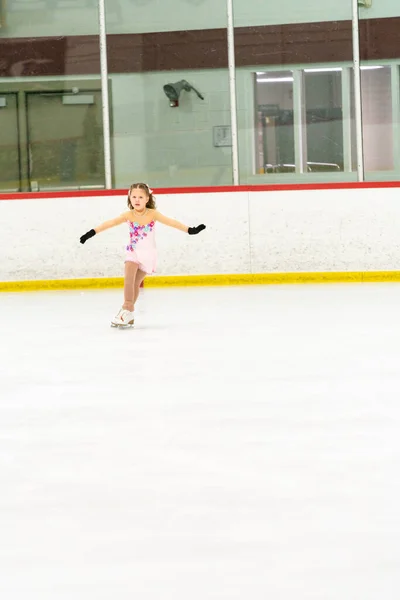 Kleines Mädchen Übt Eiskunstlauf Auf Einer Überdachten Eisbahn — Stockfoto