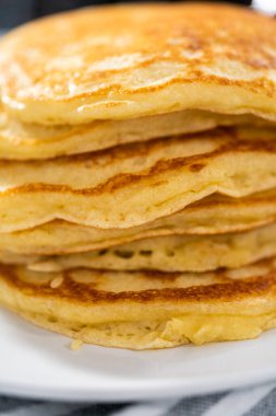 Dilimlenmiş muz, kızarmış hindistan cevizi ve akçaağaç şurubuyla süslenmiş taze hindistan cevizli krep yığını..