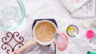 Düz yatıyordu. Adım adım. Küçük elektrikli ocağın üzerinde küçük bir tencerede karamelize şeker.