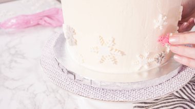 Adım adım. Yuvarlak funfetti pastasını pembe ve beyaz fondant kar taneleriyle süslüyorum..