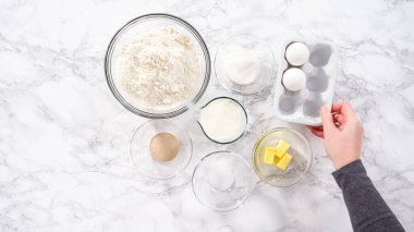 Düz yatıyordu. Adım adım. Mutfak masasında çörek pişirmek için gerekli malzemeler..