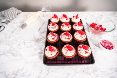 Krem peynirli kırmızı kadife kekler ve kalp ve öpücük şeklinde kırmızı çikolatalarla süslemeler..