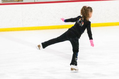 Küçük patenci sabah artistik patinaj antrenmanında elementlerini çalışıyor..