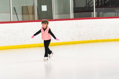 Küçük patenci sabah artistik patinaj antrenmanında elementlerini çalışıyor..