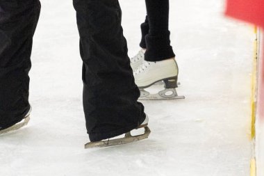 Artistik patinajda bir artistik patinajcı ve koçunun ayakları görülüyor..