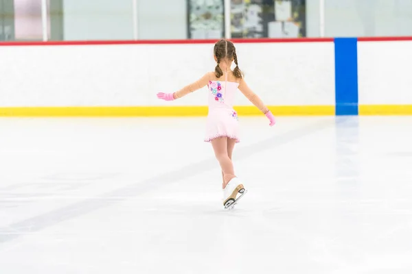 Kleines Mädchen Übt Eiskunstlauf Auf Einer Überdachten Eisbahn — Stockfoto