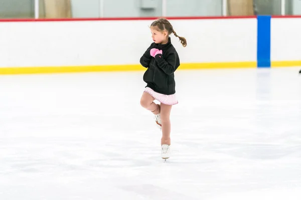 Kleines Mädchen Übt Eiskunstlauf Auf Einer Überdachten Eisbahn — Stockfoto