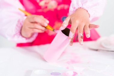 Tuvalet kağıdından tek boynuzlu at yapan küçük bir kız..