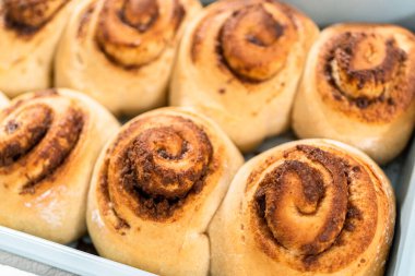 Mavi bir tavada taze pişmiş tarçınlı rulo..