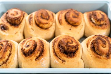 Mavi bir tavada taze pişmiş tarçınlı rulo..