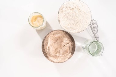 Beyaz bir tezgahta tarçınlı rulo pişirmek için gerekli malzemeler.