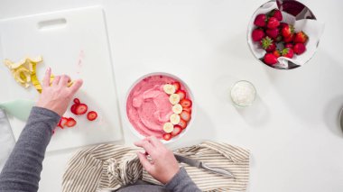 Düz yatıyordu. Hindistan cevizi gevreği ve taze meyvelerle süslenmiş çilek ve muz suyu kasesi..