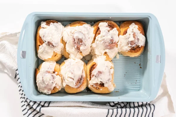 Vers Gebakken Kaneelbroodjes Met Witte Glazuur Een Blauwe Bakvorm — Stockfoto