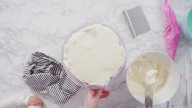 Beyaz İtalyan tereyağlı uzun yuvarlak bir pasta süslemek ve şekerli kar taneleriyle süslemek..