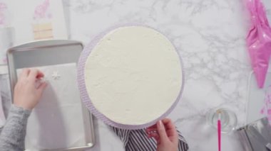 Beyaz İtalyan tereyağlı uzun yuvarlak bir pasta süslemek ve şekerli kar taneleriyle süslemek..