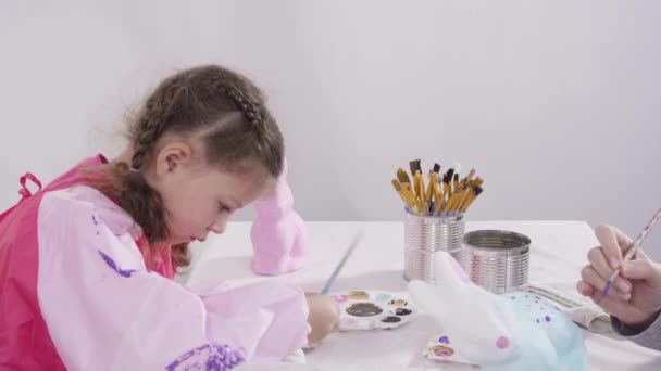 小女孩为她的家庭教育艺术项目用丙烯酸涂料画纸巾和雕像 — 图库视频影像