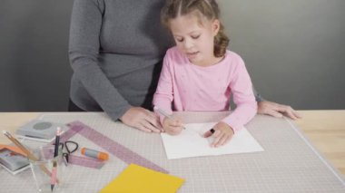 İnşaat kağıdından el yapımı Babalar Günü kartı yapan küçük bir kız..