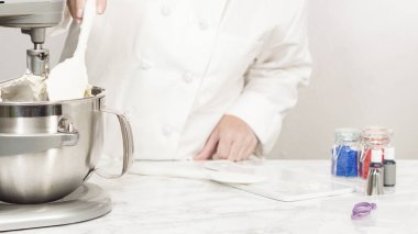 Tereyağlı krema yapmak için mutfak mikserinin malzemelerini karıştırıyorum..