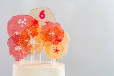 Close up of large clear pink and white lollipops with snowflakes and sprinkles. clipart