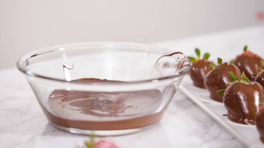 Adım adım. Erimiş çikolataya organik çilek batırmak..