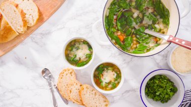 Beyaz kaselerde vejetaryen beyaz fasulye çorbası servis ediyorlar..