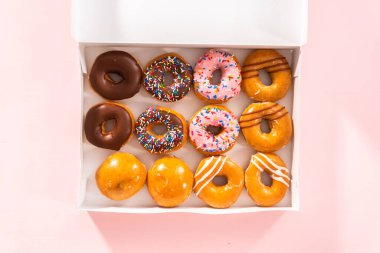 Düz yatıyordu. Beyaz bir karton kutuda mağazadan alınmış donutların çeşitliliği.