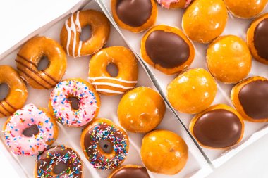 Düz yatıyordu. Beyaz bir karton kutuda mağazadan alınmış donutların çeşitliliği.