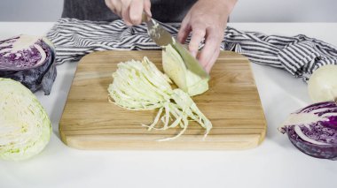 Adım adım. Ağaç kesme tahtasıyla organik lahana doğruyorum..