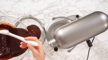 Düz yatıyordu. Adım adım. Elektrikli mutfak mikseriyle çikolatalı ganache çırpmak..