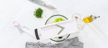 Flat lay. Slicing vegetables on slicer to make summer cucumber salad.