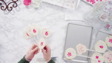 Ev yapımı lolipoplar yapmak için silikon paspaslara karamelize şeker dökmek..