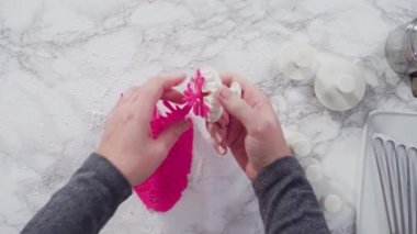 Mermer tezgahın üzerindeki beyaz fondanla kar tanelerini keserek..