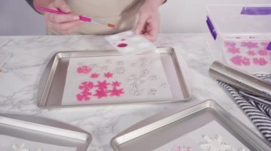 Mermer tezgahın üzerindeki beyaz yazı tipinden kurabiye keskisi ile kar tanelerini boyamak.