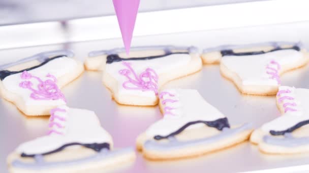 白い色のロイヤルアイシングとアイススケート形の砂糖クッキーを飾る — ストック動画