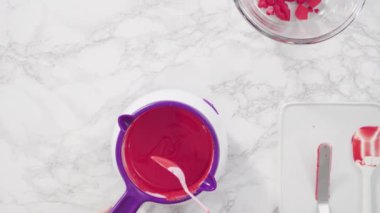 Erimiş kırmızı çikolata parçalarından çikolata kalpler ve öpücükler yapmak.