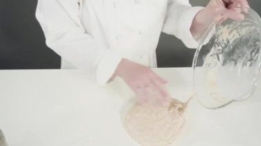 Kadın mutfakta yemek yapmak için hamur hazırlıyor.