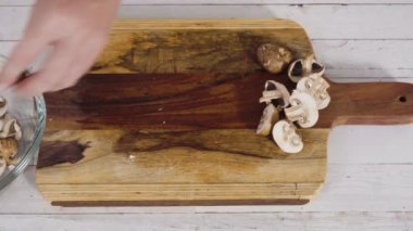 Kesme tahtasındaki dilimlenmiş mantarları kapat