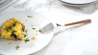 Beyaz yemek tabağında ıspanak ve jambonlu omlet..
