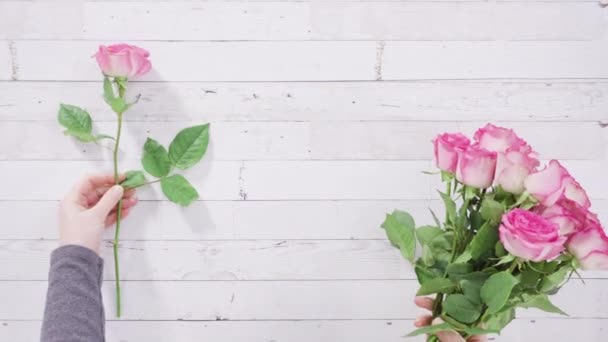 Рожеві Троянди Стеблом Пофарбованому Білому Дерев Яному Фоні — стокове відео