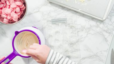 Düz yatıyordu. Adım adım. Erimiş çikolatayı kar taneleri şeklinde plastik bir çikolata kalıbına döküyorum..