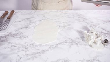 Adım adım. Beyaz fondantımızı mermer tezgahta yuvarlıyoruz..