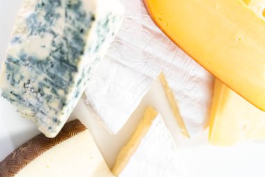 Beyaz arkaplanda geniş kama gurme peyniri çeşitliliği.