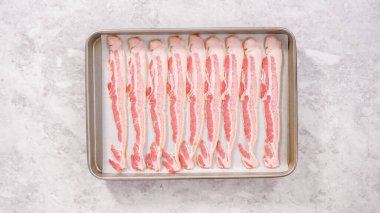 Düz yatıyordu. Adım adım. Pişmemiş pastırma şeritleri ve beyaz parşömen kağıtları..