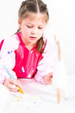Küçük kız COVID-19 salgınında evde uzaktan öğrenim için sanat projesi üzerinde çalışıyor..