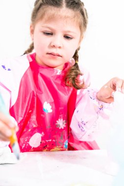 Küçük kız COVID-19 salgınında evde uzaktan öğrenim için sanat projesi üzerinde çalışıyor..