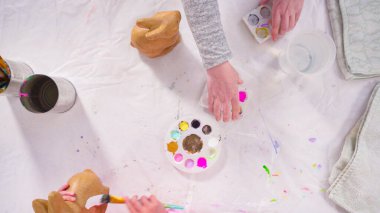 Düz yatıyordu. Evde resim dersinde kağıt heykel boyayan küçük bir kız..