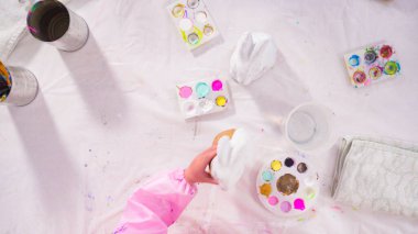 Düz yatıyordu. Evde resim dersinde kağıt heykel boyayan küçük bir kız..