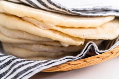 Mutfak havlusuna sarılı taze pişmiş ekmek yığını..