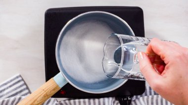 Adım adım. Düz yatıyordu. Elektrikli tavanın üzerine küçük bir tencereyle şeker şurubu hazırlıyorum..